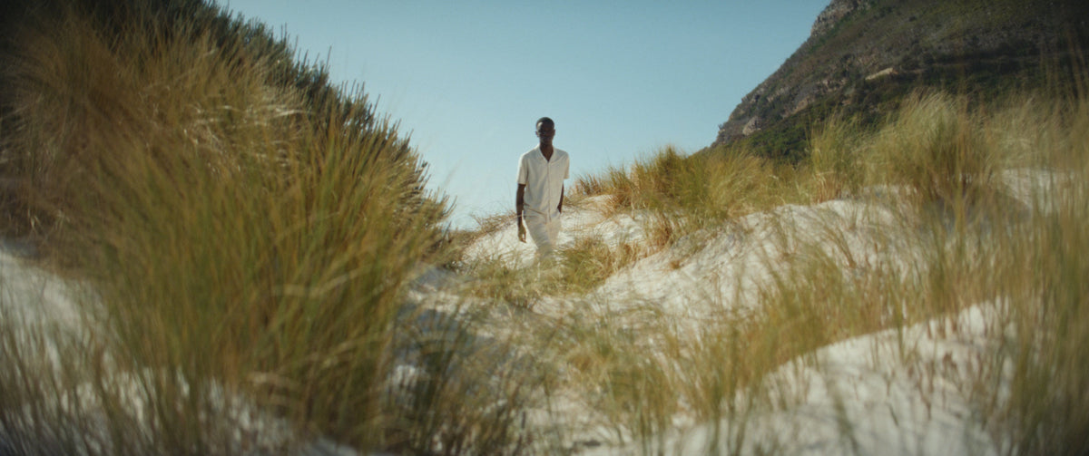 A model walking between coastal dunes, from the Boxfish archive